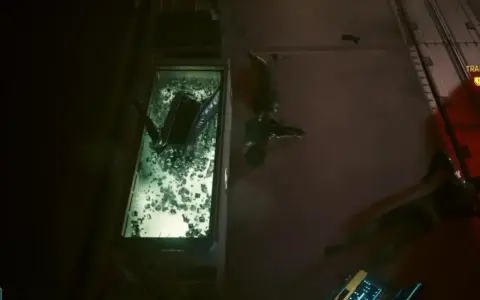 W szklanej kapsule leży ciało, obok wiszą inne. To mroczny obraz cyberpunk czynnik ludzki.