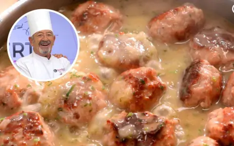Chef Karlos Arguiñano sonríe junto a una cazuela de deliciosas albóndigas con tomate y salsa cremosa.