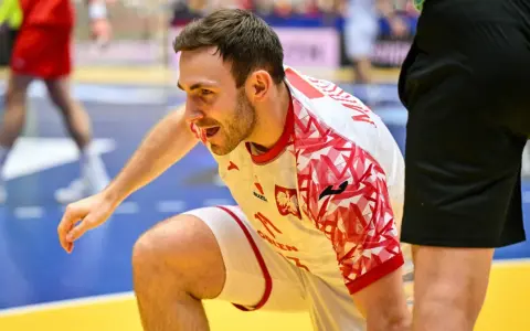 Arkadiusz Moryto w białej koszulce z czerwonymi wzorami, w akcji na boisku.