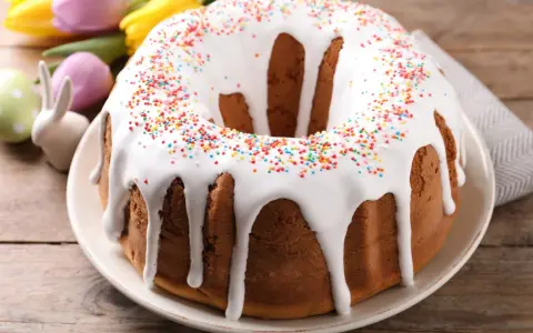 Pyszna babka z białym lukrem i kolorową posypką, gotowa na Wielkanoc.