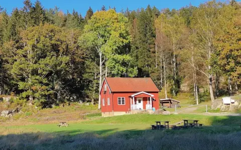 Rött hus i Svartedalen, perfekt för en vandring. Höstfärger i skogen och en solig äng.