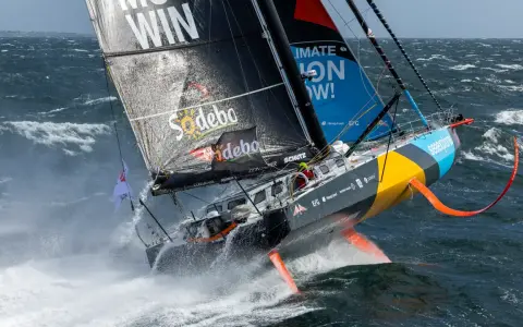 Ein Segelboot kämpft sich durch hohe Wellen, ein Teilnehmer der Segelregatta um die Welt.