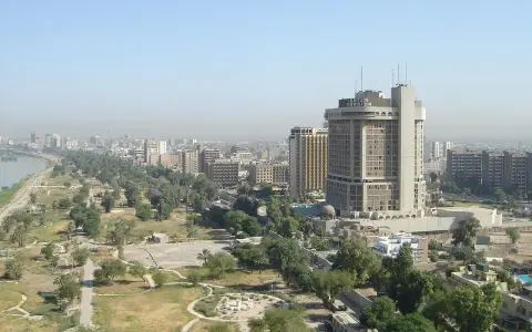 Bagdad, ojczyzna Sindbada Żeglarza, z hotelem Ishtar Sheraton i zielonymi terenami nad rzeką.