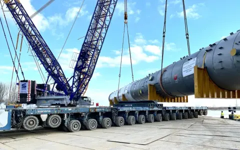 Największy transport w Polsce: potężny dźwig Sarens podnosi ogromny element instalacji na wielokołową platformę.