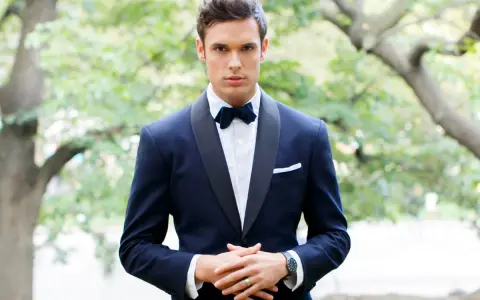 Uomo con smoking blu scuro, papillon e fazzoletto bianco. Il colore abito padre dello sposo è elegante e raffinato.