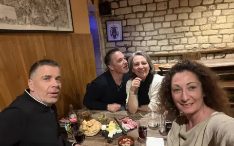 Ambiance chaleureuse dans la taverne médiévale Paris. Quatre amis partagent un repas convivial, entre rires et dégustations.