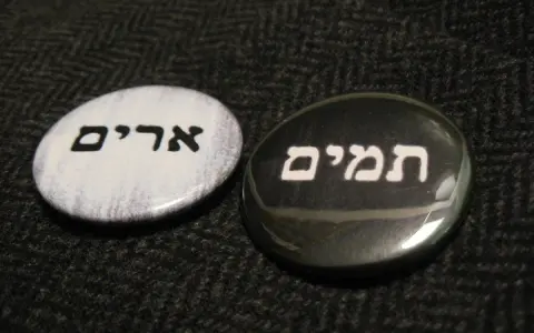 Two round pins with Hebrew text: "Urim" on a white background and "Thummim" on a black background.