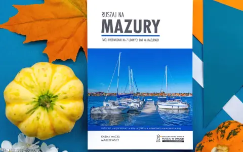 Przewodnik "Ruszaj na Mazury" z widokiem na żaglówki i jesienne dekoracje. Idealny pomysł na mazury na weekend.