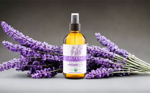 Butelka z organiczną wodą lawendową Alteya Organics otoczona bukietami fioletowej lawendy.