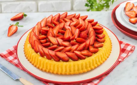 Una deliziosa crostata morbida alle fragole, con la sua base dorata e un abbondante strato di fragole fresche affettate.