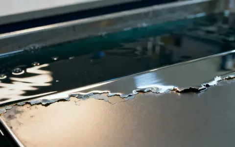 Metalowa powierzchnia z odpryskującym chromem, zanurzona w płynie. Zastanawiasz się, czym wyczyścić chrom?
