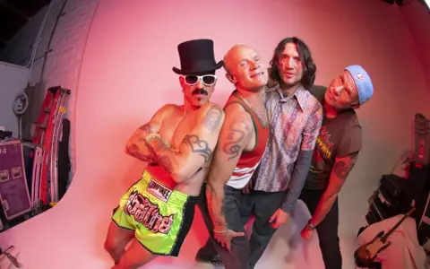 Les membres de Red Hot Chili Peppers posent ensemble, un groupe de rock iconique.