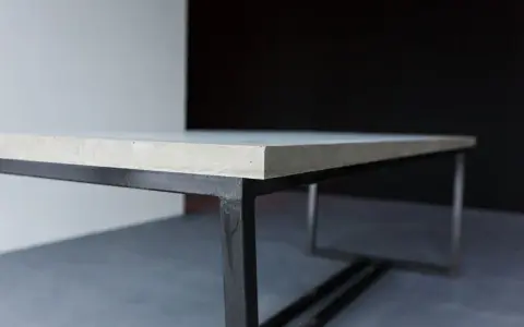 En stilren betongskiva på ett svart metallunderrede. Ytan är behandlad för att impregnera betongskivan och skydda den.