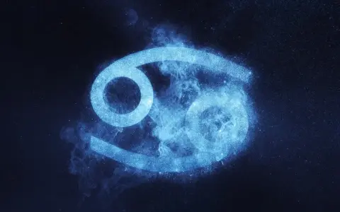 Błękitny symbol Raka, otoczony mgiełką i pyłem gwiezdnym, symbolizuje jego emocjonalne i opiekuńcze cechy charakteru.