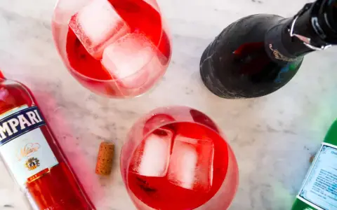 Idealny Campari Spritz przepis: Aperitif z Campari, prosecco i wodą gazowaną, podany z lodem.
