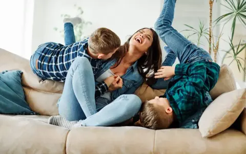 Szaleństwo na kanapie: matka śmieje się, otoczona przez dzieci. Ich więź jest tak silna, że można by ją nazwać syndromem sztokholmskim.