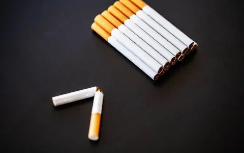 Kilka papierosów ułożonych w rzędzie i jeden złamany na pół.