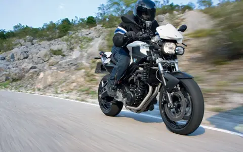 Motocyklista w kasku jedzie na BMW F800R po krętej drodze. Poznaj jego dane techniczne.