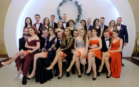 Uczniowie na studniówce, dziewczyny w sukniach, a jedna z nich ma widoczne czerwone majtki na studniówkę.