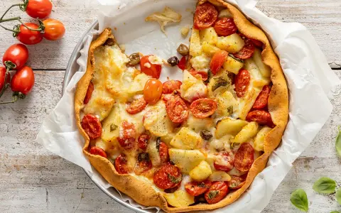 Torta salata estiva con patate, pomodorini e formaggio filante, un tripudio di sapori mediterranei.
