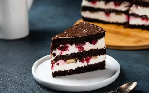Kawałek czekoladowego tortu z kremem mascarpone, malinami i bananem. Idealny, bardzo łatwy tort z mascarpone na deser.