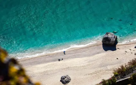Spiaggia dorata e mare turchese in Liguria. Un pescatore solitario ammira la bellezza del **liguria mare**.