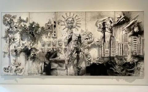 Œuvre monumentale de Niki de Saint Phalle, mêlant figures, masques, un soleil menaçant et une ville, évoquant des tirs symboliques.