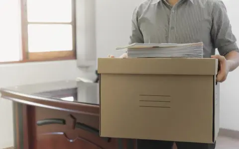 Hombre con caja de cartón y papeles, listo para irse. ¿Los 15 días de preaviso son naturales o laborales?