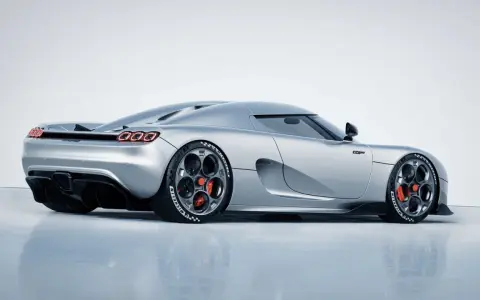 Srebrny Koenigsegg CC850 z czerwonymi zaciskami hamulcowymi i charakterystycznymi felgami.