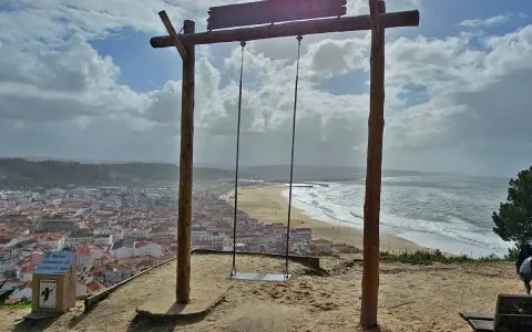 Schaukel über Nazaré, wo die Wellen tosen. Ein atemberaubender Blick auf die Stadt und das Meer.
