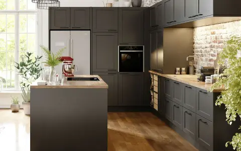 Cuisine gris anthracite avec un mur en briques apparentes. Un îlot central et des meubles sombres créent une ambiance moderne.