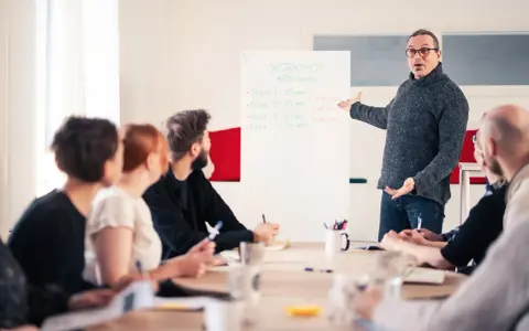 Man leder en workshop om möteskultur, där deltagarna fokuserar på kompetens utveckling.