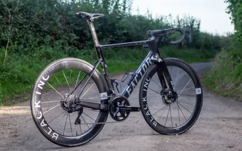 A black Factor Ostro VAM road bike with Black Inc wheels sits on a dirt path, ready for an adventure.