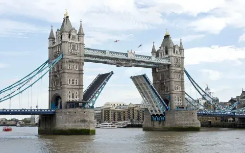 Torre de Londres con sus **puentes levadizos** abiertos, permitiendo el paso de barcos por el río Támesis.