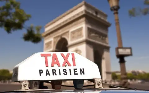 Un taxi parisien con el Arco del Triunfo de fondo.
