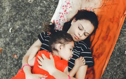 Mama i dziecko leżą przytuleni, uosabiając sztukę prostego życia. Ich spokój i bliskość to najpiękniejszy obraz.