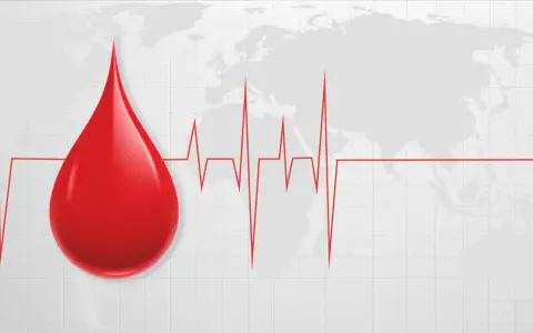 Kropla krwi i EKG na tle mapy świata. Symbolizuje to globalne znaczenie transfuzji i potrzebę pomocy, zwłaszcza gdy w grę wchodzą najrzadsze grupy krwi.