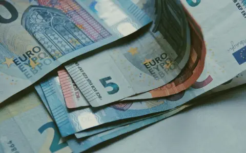 Euro banknoty, w tym 5, 20 i 50 euro, leżące na stole. Zastanawiasz się, jak rozliczyć się z ubezpieczenia w Holandii?