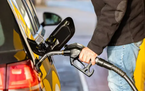 Tankowanie samochodu z silnikiem diesla. Dłoń trzyma pistolet paliwowy z napisem Diesel B0.