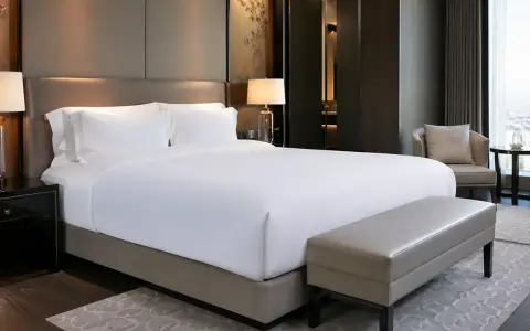 Cama de hotel con sábanas blancas impecables. ¿De qué marca son los colchones de los hoteles? Este lujoso dormitorio invita al descanso.