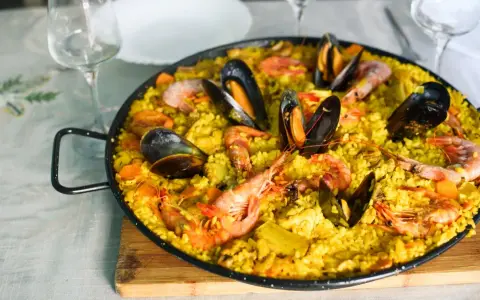 Pyszna paella z owocami morza, idealne hiszpania jedzenie. Krewetki i małże na żółtym ryżu.
