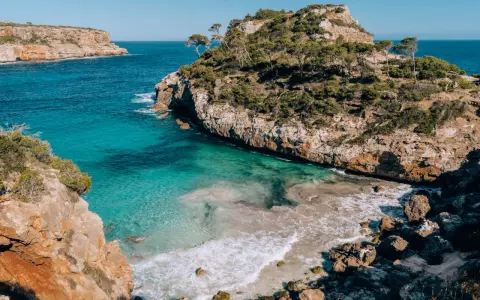 Malownicze wybrzeże z turkusową wodą i skalistymi klifami, idealne miejsce na wakacje na Palma de Mallorca.
