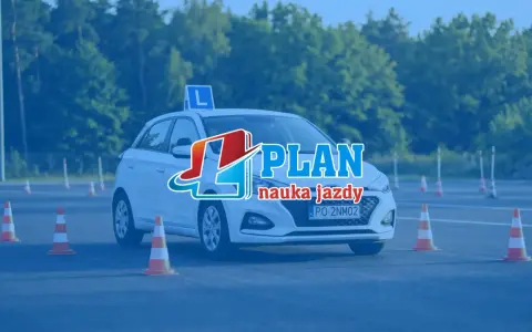 Biały samochód z literą "L" na dachu i pachołkami na placu manewrowym. To idealne miejsce na praktyczny egzamin na prawo jazdy.