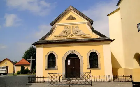 Żółta kaplica czaszek w Czermnej z aniołami i napisem "Kaplica Czaszek".