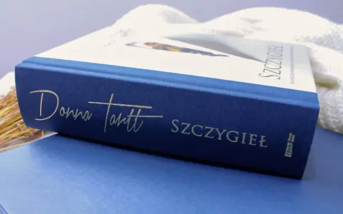 Granatowa okładka książki "Szczygieł" Donny Tartt z wytłoczonym złotym napisem.