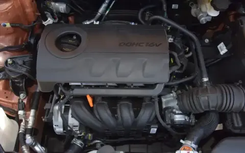 Silnik 1.4 MPI DOHC 16V w samochodzie. Widoczne elementy układu dolotowego i osłona silnika.