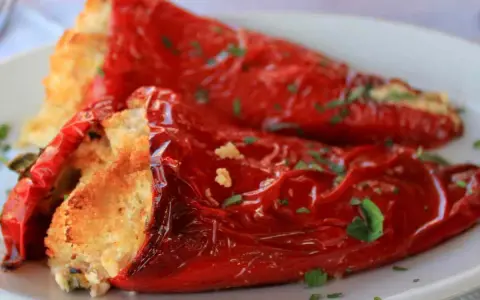 Peperoni ripieni in padella, dorati e profumati, con un ripieno invitante e una spolverata di prezzemolo fresco.