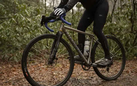 Cyclist adjusting saddle height to prevent calf pain.