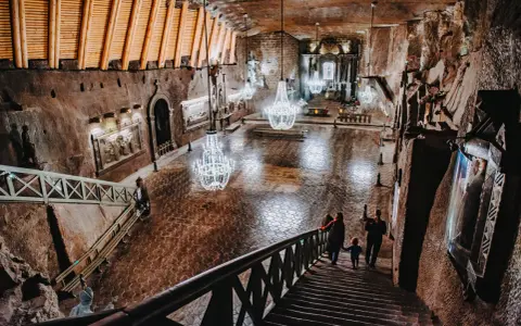 Wielka komora w kopalni soli w Wieliczce, z kryształowymi żyrandolami. Sprawdź kopalnia soli wieliczka cennik, by poznać ceny biletów.