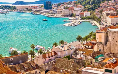 Vacker kuststad i Kroatien med turkost vatten och båtar. En drömresa, kanske med vaccin Kroatien i åtanke för en trygg semester.